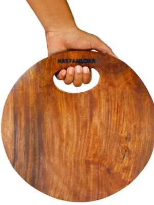 Sheesham-single-block-wood-round-choper-board-holding Chef & Food Blogger Favourite Hardwood Single Block Wood Shesam Wooden Chopping Board, 27 x 27 x 6 cm, 1 kg, Heavy Duty, Non-Slip Fruit Meats Vegetable Cutting Board Premium Finish